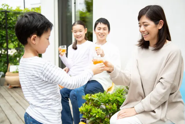 バルコニーでお茶を飲む家族