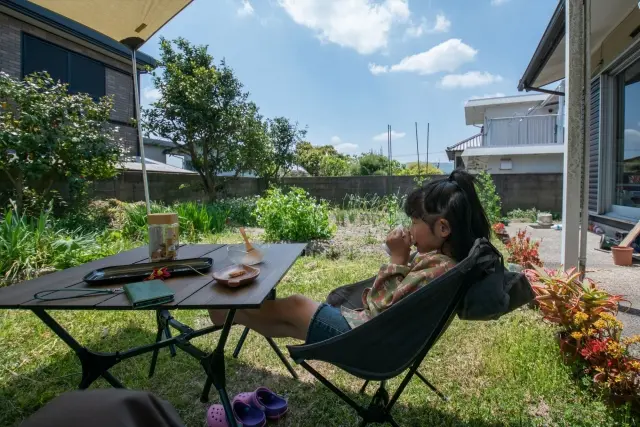庭にある日よけで涼む子ども